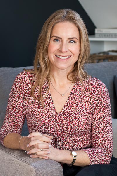 Indoor headshot of interior designer sitting on sofa