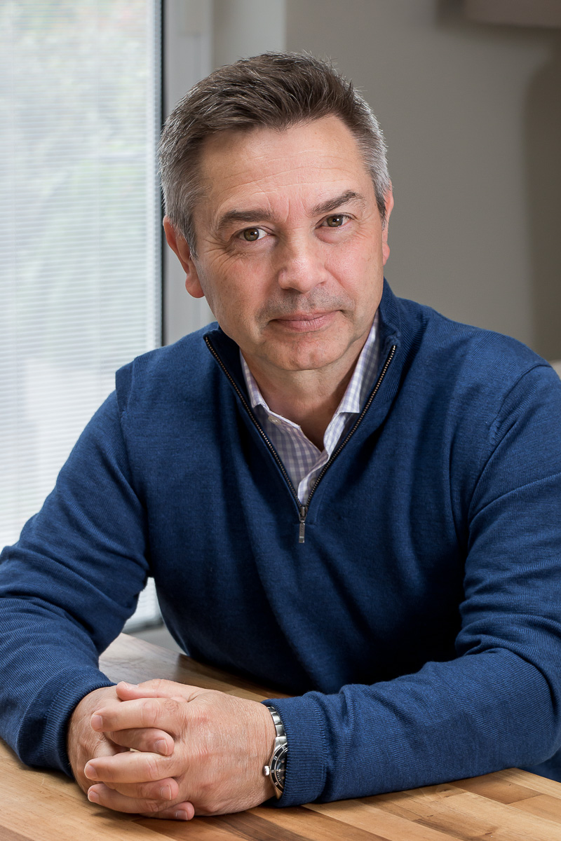 Male headshot indoors sitting at table